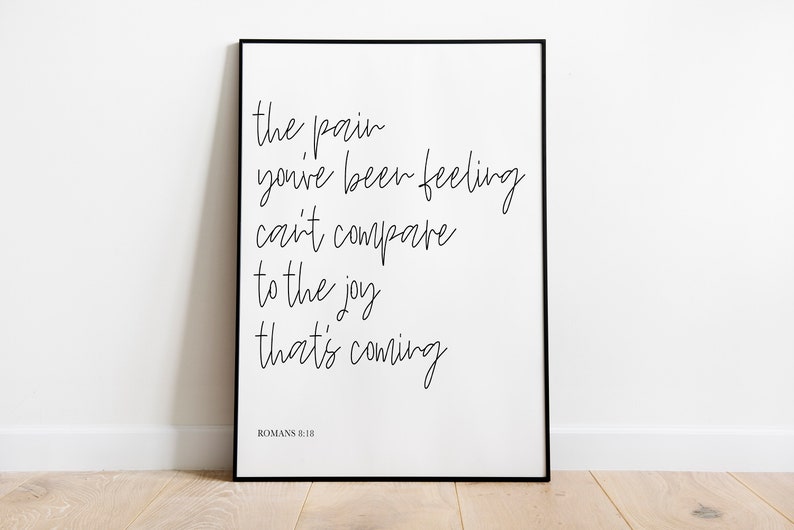 May include: Black and white framed print with the text "the pain you've been feeling can't compare to the joy that's coming" and "ROMANS 8:18" at the bottom.