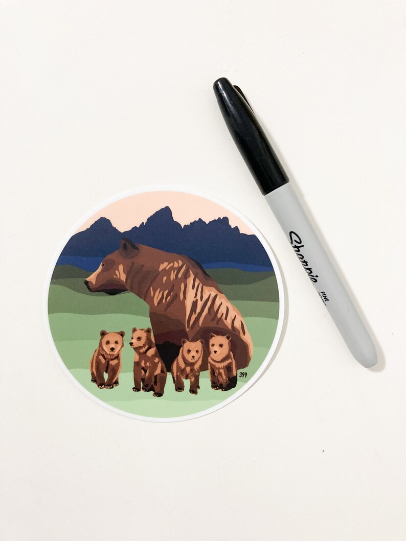May include: A brown bear with four cubs in a mountain landscape. The bear and cubs are standing on a green grassy area with a blue lake and mountains in the background. The sky is a light pink color.