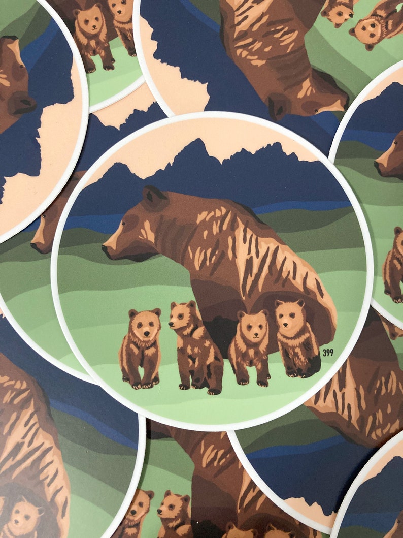 May include: A brown bear with four cubs stands in a green field with a blue mountain range in the background. The bear and cubs are all facing the right side of the image. The image is a sticker with a white border and the number 399 printed in the bottom right corner.