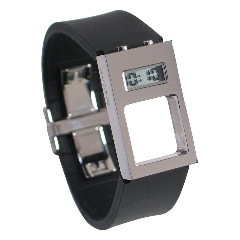 Op de afbeelding: Een zilveren digitale horloge met een zwarte rubberen band. De wijzerplaat van het horloge is rechthoekig en heeft een uitsparing in het midden. De wijzerplaat van het horloge geeft de tijd 11:11 aan. Het merk van het horloge is ACME.