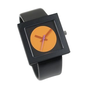 K&ouml;nnte beinhalten: Eine schwarze quadratische Uhr mit einem schwarzen Lederarmband. Das Zifferblatt der Uhr ist ein leuchtend orangefarbener Kreis mit schwarzen Zeigern und einem violetten Sekundenzeiger.