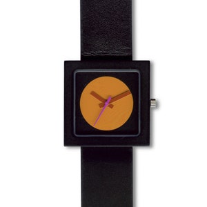 K&ouml;nnte beinhalten: Eine schwarze quadratische Uhr mit einem schwarzen Lederarmband. Das Zifferblatt der Uhr ist ein Kreis mit orangefarbenem Hintergrund und rosa und braunen Zeigern.