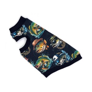 May include: A black dog shirt featuring a repeating pattern of cartoon fish wearing hats, sunglasses, and gold chains. The fish are in various colors, including green, orange, and blue. The shirt has black trim.