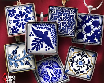 May include: A set of six blue and white ceramic tiles with intricate patterns, including a bird, flowers, and geometric designs. The tiles are framed in silver and are arranged on a red background.