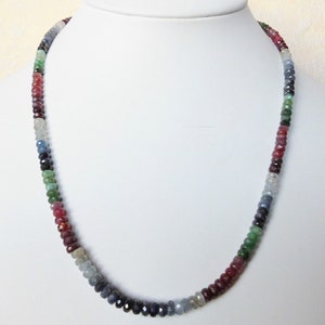 May include: A multi-colored gemstone necklace with faceted beads in shades of blue, green, and red. The necklace is made of small, round beads and is approximately 18 inches long.