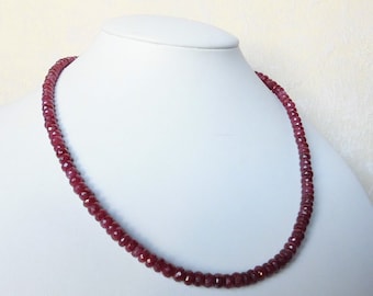 Op de afbeelding: Een ketting gemaakt van kleine, gefacetteerde robijn kralen. De kralen zijn diep rood van kleur en zijn geregen op een dunne zilveren ketting.