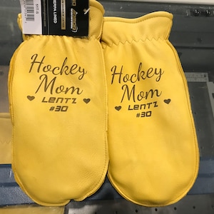 May include: A pair of yellow leather mittens with the text "Hockey Mom Lentz #30" embroidered on each mitten.