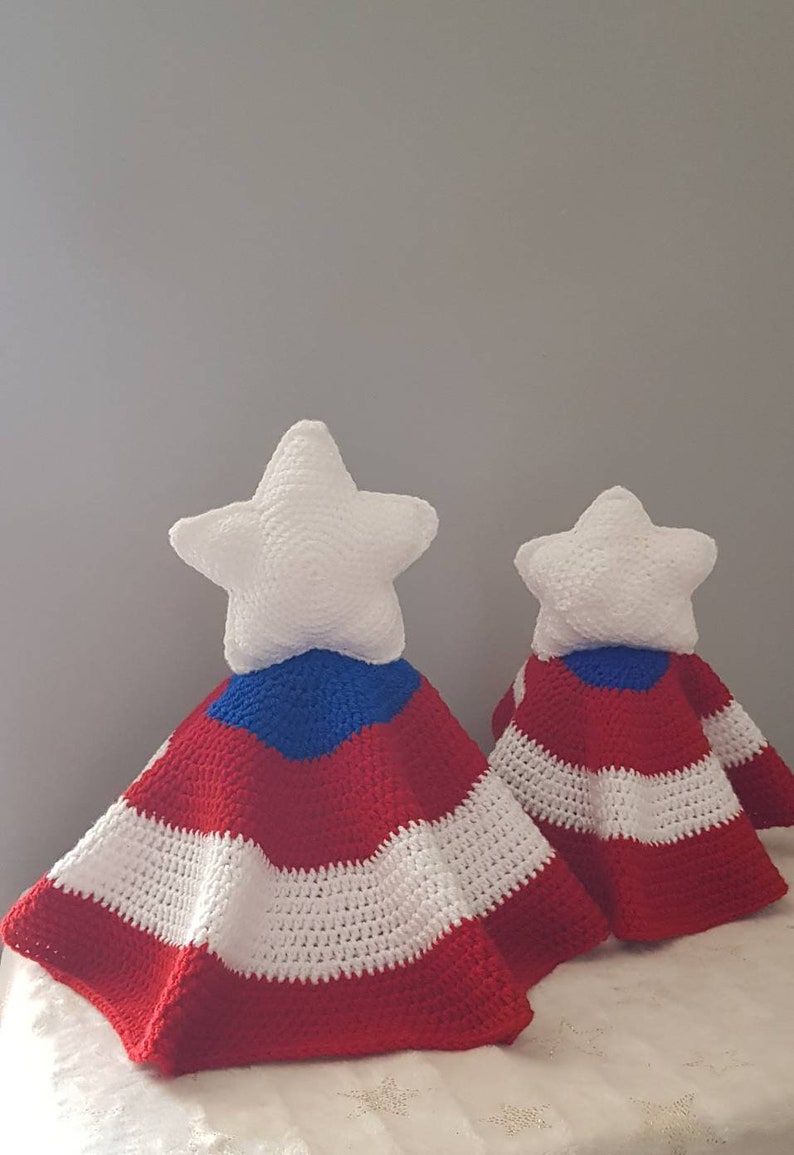 May include: Two crocheted star-shaped pillows with red, white, and blue striped blankets. The star pillows are white, and the blankets have a patriotic design. The items are handmade and suitable for home decor.