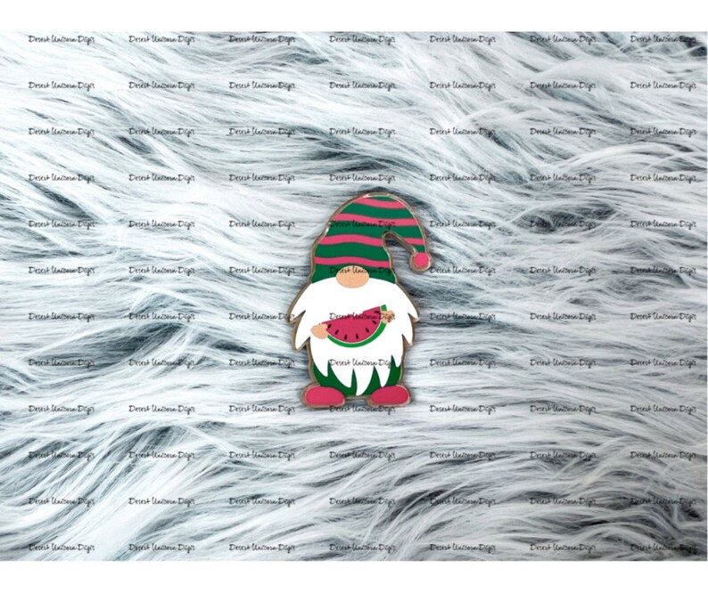May include: A wooden gnome figurine with a red and white striped hat and a white beard. The gnome is holding a slice of watermelon in its hands. The gnome is standing on a white furry background.