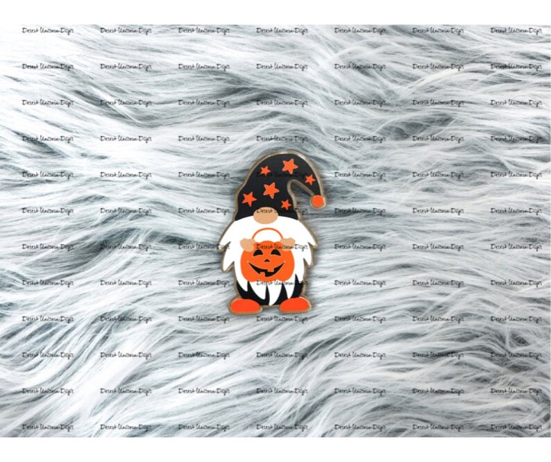 May include: A Halloween gnome with a black hat and a pumpkin face. The gnome is wearing a black and orange outfit and is holding a small pumpkin.