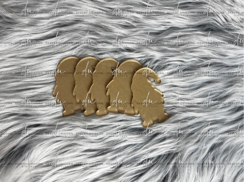 May include: Four gold-coloured gnome ornaments with white beards and red hats. The gnomes are standing on a grey fuzzy surface.