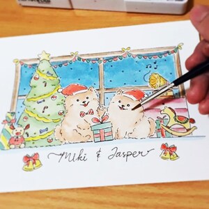 May include: A watercolor painting of two fluffy white dogs wearing Santa hats and sitting in front of a window with a Christmas tree. The dogs are holding presents and the text "Miki & Jasper" is written below them.