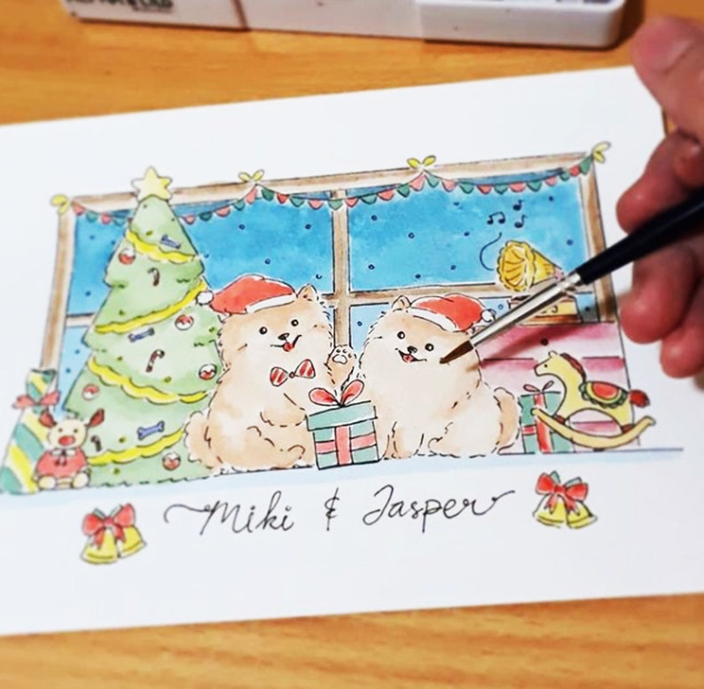 May include: A watercolor painting of two fluffy white dogs wearing Santa hats and sitting in front of a window with a Christmas tree. The dogs are holding presents and the text "Miki & Jasper" is written below them.