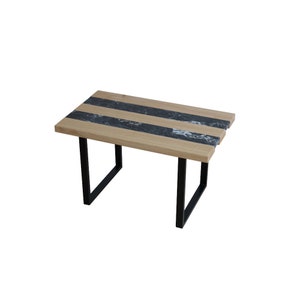 Peut inclure: Une table rectangulaire en bois avec un incrustation de marbre noir et des pieds en métal noir.