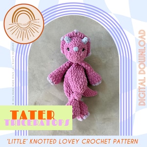 Pode incluir: Um brinquedo triceratops rosa de crochê com detalhes cinzentos nos chifres e pés. O brinquedo faz parte de um padrão de crochê para download digital. O texto "TATER TRICERATOPS" é exibido em um retângulo verde, com "DOWNLOAD DIGITAL".