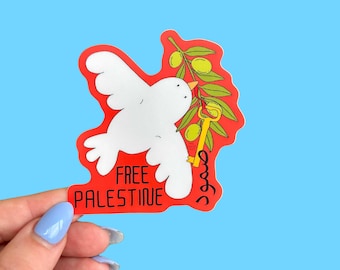 May include: A sticker with a red border featuring a white dove carrying an olive branch with green olives and a gold key. The words "FREE PALESTINE" are printed in white on a red banner.