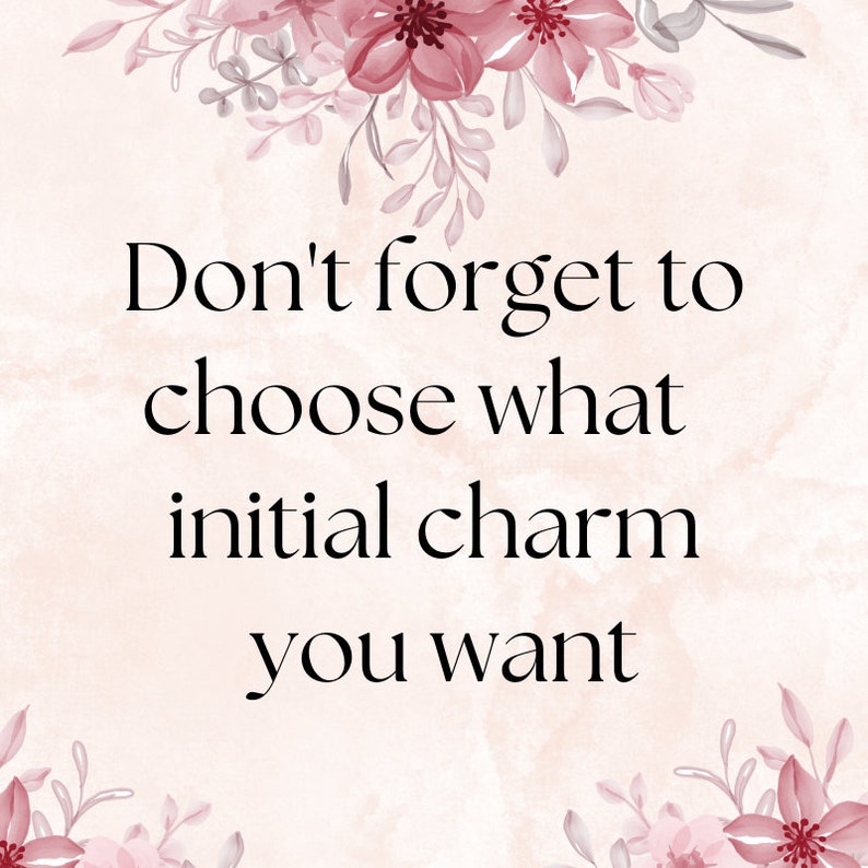 May include: A pale pink background with dark pink floral illustrations at the top and bottom. The text in black reads: Don't forget to choose what initial charm you want. The design features a soft watercolor texture throughout the entire image.
