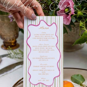 May include: A menu card with a pink and green striped background and a pink wavy border. The menu lists entrees, main courses, vegetarian options, desserts, and wines. The Wildflower Estudio logo is at the top and bottom.