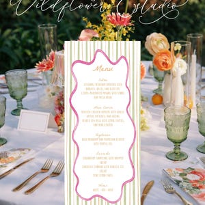 May include: A menu card with a pink wavy border and green and white striped background. The menu lists entrees, main courses, vegetarian options, desserts, and wines. The Wildflower Estudio logo is in the top left corner.