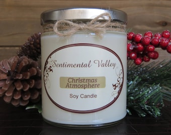 May include: A white soy candle in a glass jar with a silver lid. The jar has a label that says "Sentimental Valley" and "Christmas Atmosphere".
