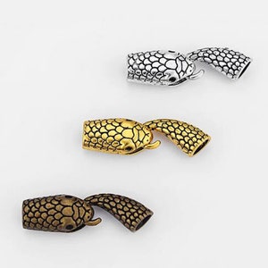 Pu&ograve; includere: Tre chiusure in metallo a forma di serpente in finiture argento, oro e oro antico. Ogni chiusura presenta una testa di serpente dettagliata e un corpo testurizzato.