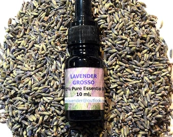 May include: A black glass bottle of Lavender Grosso 100% Pure Essential Oil, 10 ml, with a dropper, sits on a bed of dried lavender buds. The label includes the email address: elslavender@outlook.com.