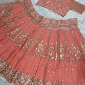Peach Lehenga Choli with Antique Gold Potli and Meenakari Pearl Necklace Set - Rental main image 0