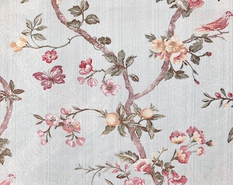 May include: A light blue fabric with a floral pattern featuring pink flowers, green leaves, and brown branches. The pattern is repeated throughout the fabric.