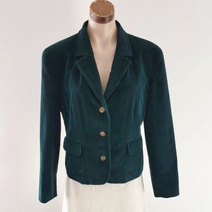 Vintage 80s 90s Green Corduroy Jacket with lower front pockets antique gold coloured buttons through to V neck and pointed collar long sleeves with matching button detail to cuff small enclosed shoulder pads fully lined and lower back shaping belt. Labelled Thomas Burberry made in England.

This Thomas Burberry labels appear to have been around from the late 1980s to the early 2000s perhaps as a marketing decision to recognise the anniversary of the founder Thomas Burberry.