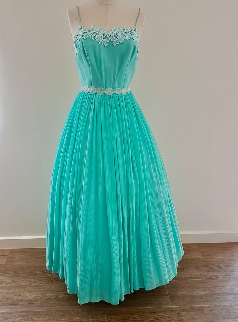 50s Mint Green Chiffon Ball Formal Gown Dress fitted bodice with guipere lace and rhinestone detail thin shoulder straps full ankle length skirt. Made in Australia by Ninette Creations of Melbourne.
bust to 85cm waist to 63cm hips to 90cm