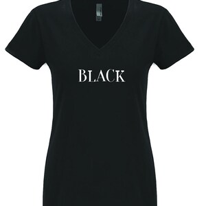 May include: Black v-neck t-shirt with the word "BLACK" printed in white on the front.