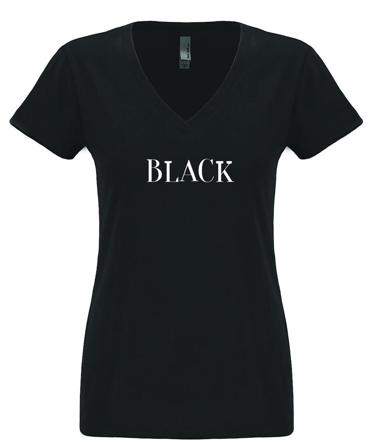 May include: Black v-neck t-shirt with the word "BLACK" printed in white on the front.