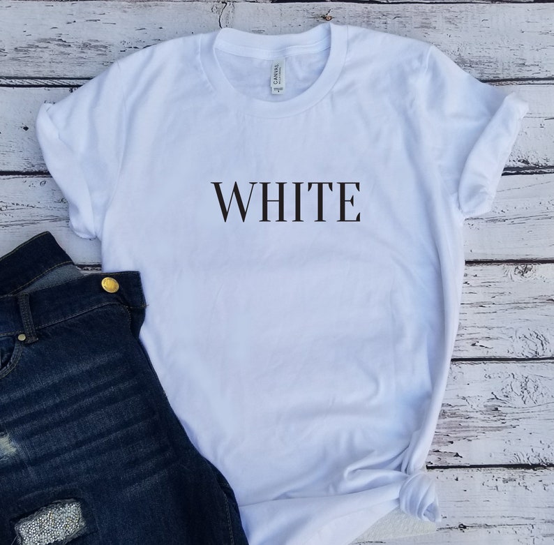 May include: White t-shirt with the word "WHITE" printed in black on the front.