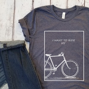 Puede incluir: Una camiseta gris oscuro con un gr&aacute;fico blanco de una bicicleta y el texto "I WANT TO RIDE MY".