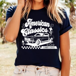 Puede incluir: Una camiseta azul marino con un gr&aacute;fico blanco de un coche cl&aacute;sico y el texto "American Classics Summer Cruise".