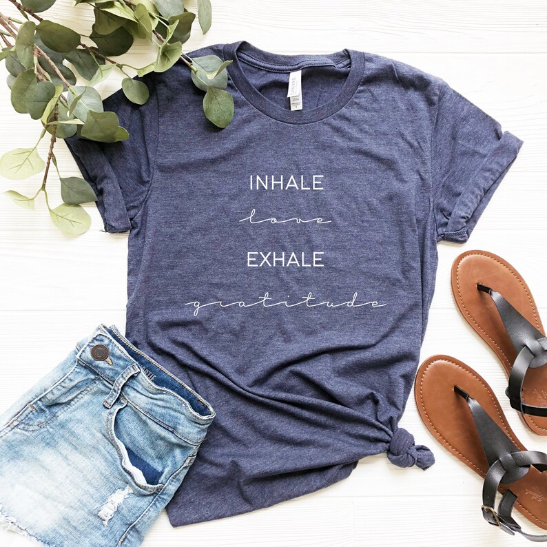 May include: A navy blue t-shirt with the text "INHALE love EXHALE gratitude" printed in white.