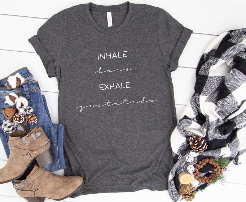 May include: A dark gray t-shirt with the text "INHALE love EXHALE gratitude" printed in white on the front.