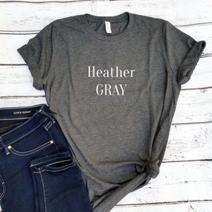 以下が含まれることがあります： ヘザーグレーのTシャツで、前面に白い文字で「Heather Gray」とプリントされています。