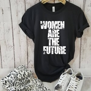 May include: Black t-shirt with the text "Women Are The Future" printed in white. The text has a distressed, vintage look.