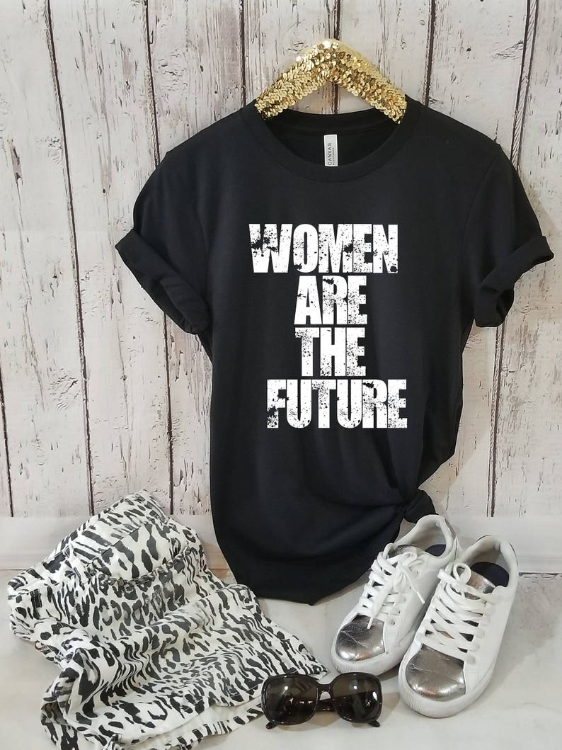 May include: Black t-shirt with the text "Women Are The Future" printed in white. The text has a distressed, vintage look.