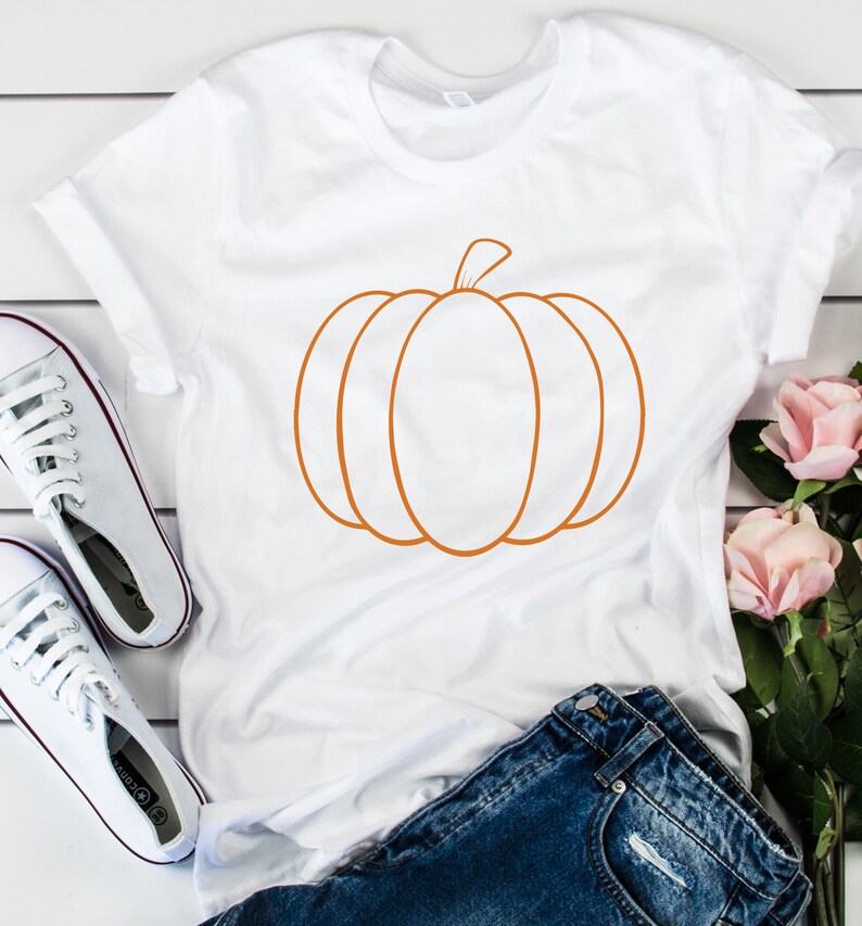 May include: White t-shirt with an orange outline of a pumpkin.
