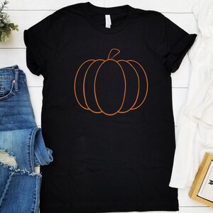 May include: Black t-shirt with an orange outline of a pumpkin.