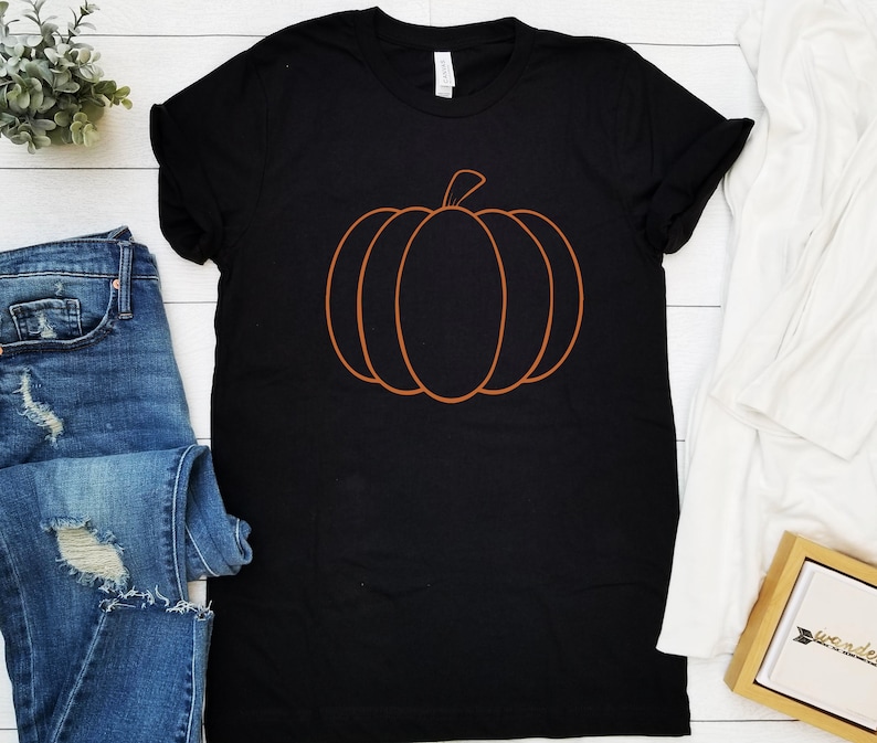 May include: Black t-shirt with an orange outline of a pumpkin.