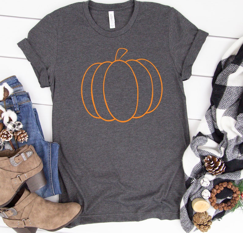 May include: A dark gray t-shirt with an orange outline of a pumpkin on the front.