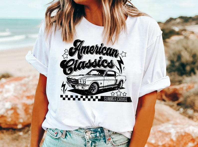 Puede incluir: Camiseta blanca con un dise&ntilde;o gr&aacute;fico negro que presenta un coche cl&aacute;sico y el texto "American Classics Summer Cruise".