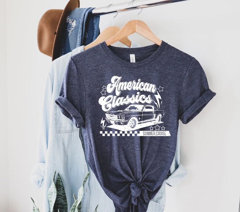 Puede incluir: Una camiseta azul marino con un gr&aacute;fico blanco de un coche cl&aacute;sico y el texto "American Classics" y "Summer Cruise".