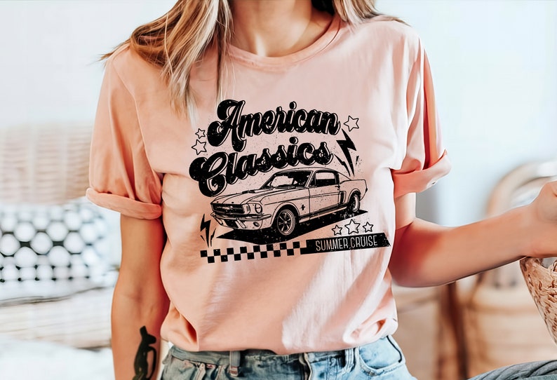 Puede incluir: Una camiseta rosa con un gr&aacute;fico negro de un coche cl&aacute;sico y el texto "American Classics Summer Cruise".