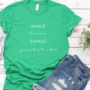 May include: Green t-shirt with white text that reads "INHALE love EXHALE gratitude".
