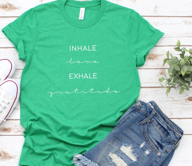 May include: Green t-shirt with white text that reads "INHALE love EXHALE gratitude".