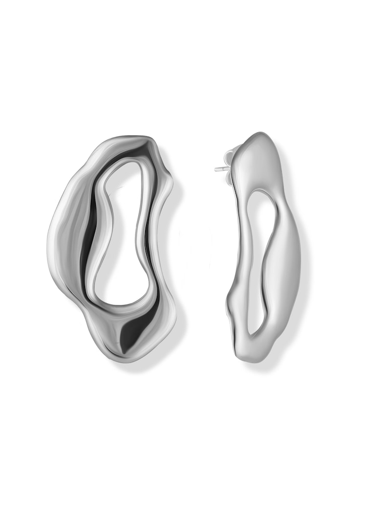 A pair of silver abstract earrings. The earrings are shaped like a wavy, organic form with a cutout in the center. The earrings are a modern and stylish design.